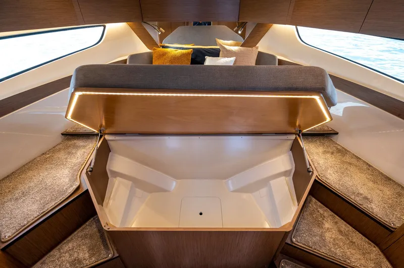 Slide: The Image of 2025 Beneteau Antares 11 Fly interior with open storage compartment and modern seating. - 33