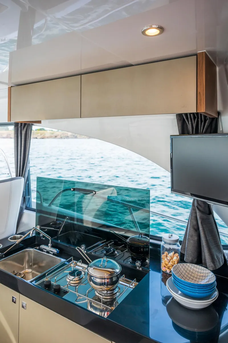 Slide: The Image of 2025 Beneteau Antares 11 Fly kitchen with modern appliances and ocean view. - 43