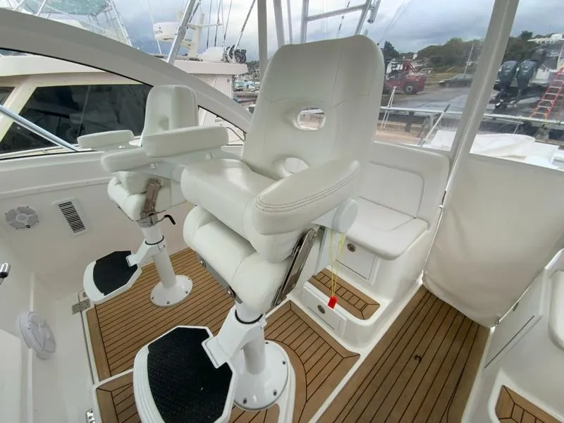 Slide: The Image of 2022 Albemarle 360 Express Fisherman cockpit with white captain chairs and teak flooring. - 45
