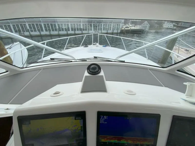Slide: The Image of 2022 Albemarle 360 Express Fisherman helm with navigation screens, docked at marina. - 56