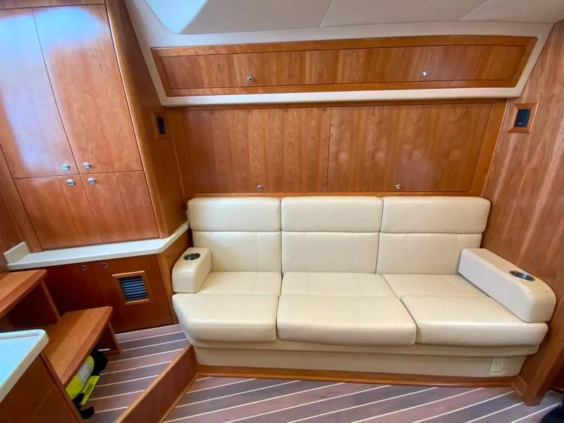 Slide: The Image of 2022 Albemarle 360 Express Fisherman interior with beige leather sofa and wooden cabinetry. - 61