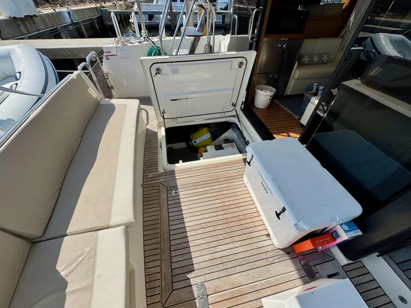 Slide: The Image of 2020 Beneteau Swift Trawler 47 deck with open storage hatch and seating area. - 10