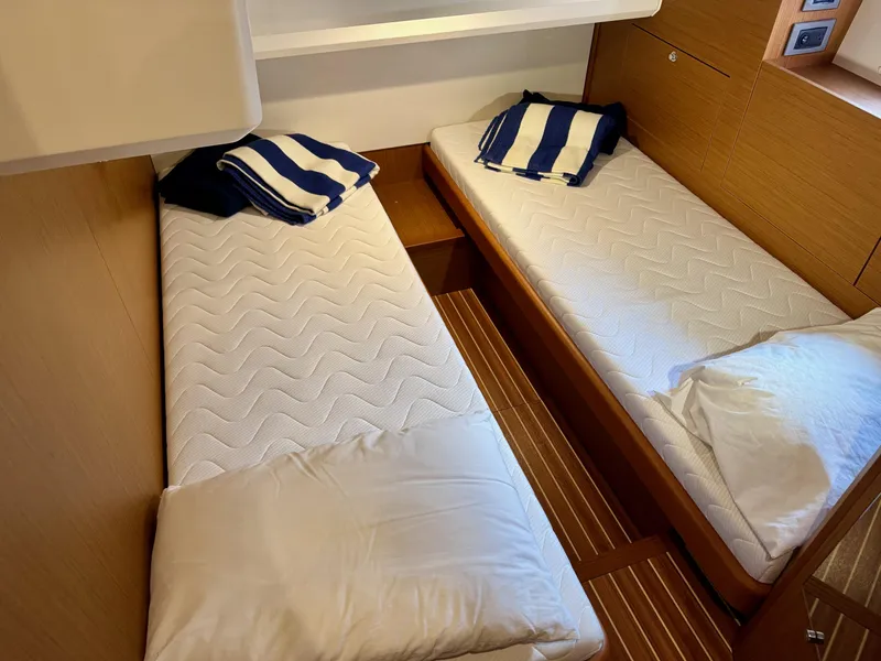 Slide: The Image of Twin beds in 2020 Beneteau Swift Trawler 47 cabin with striped pillows. - 12