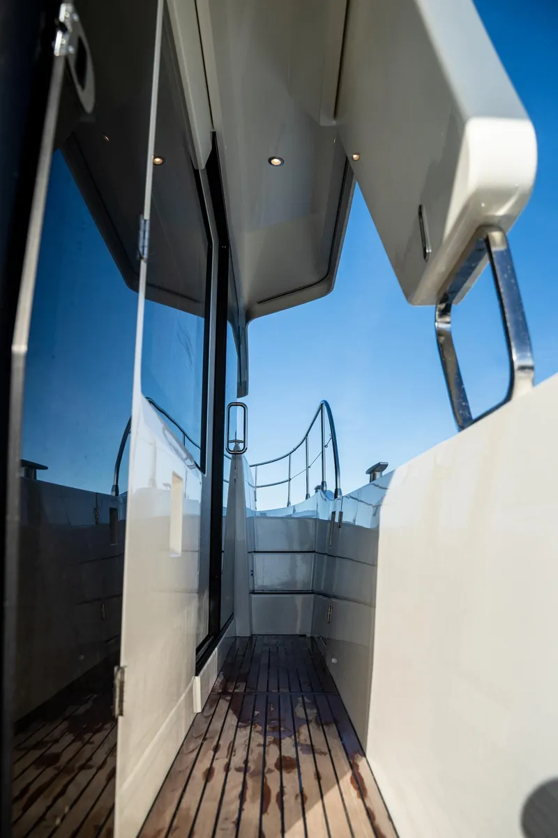Slide: The Image of 2020 Beneteau Swift Trawler 47 side deck with wooden flooring and sleek design. - 14
