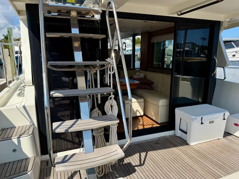 Slide: The Image of Beneteau Swift Trawler 47, 2020 model, featuring outdoor stairs and cozy interior seating. - 16
