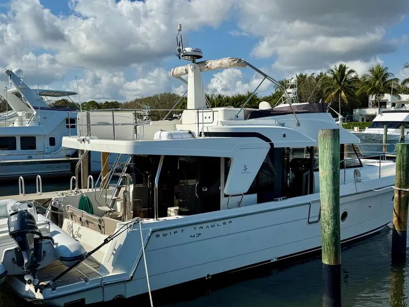 Slide: The Image of 2020 Beneteau Swift Trawler 47 docked at marina under cloudy sky. - 18