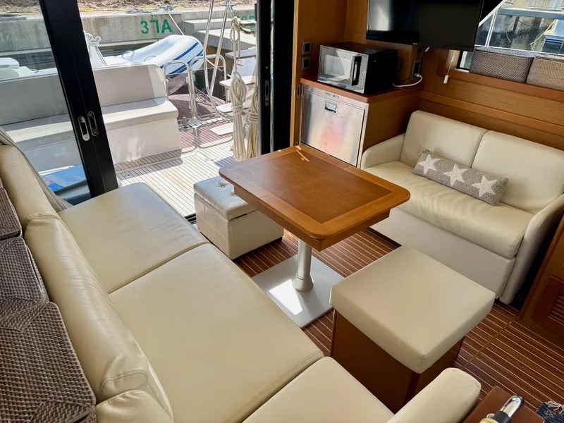 Slide: The Image of Interior of 2020 Beneteau Swift Trawler 47 with seating, table, and kitchenette. - 2