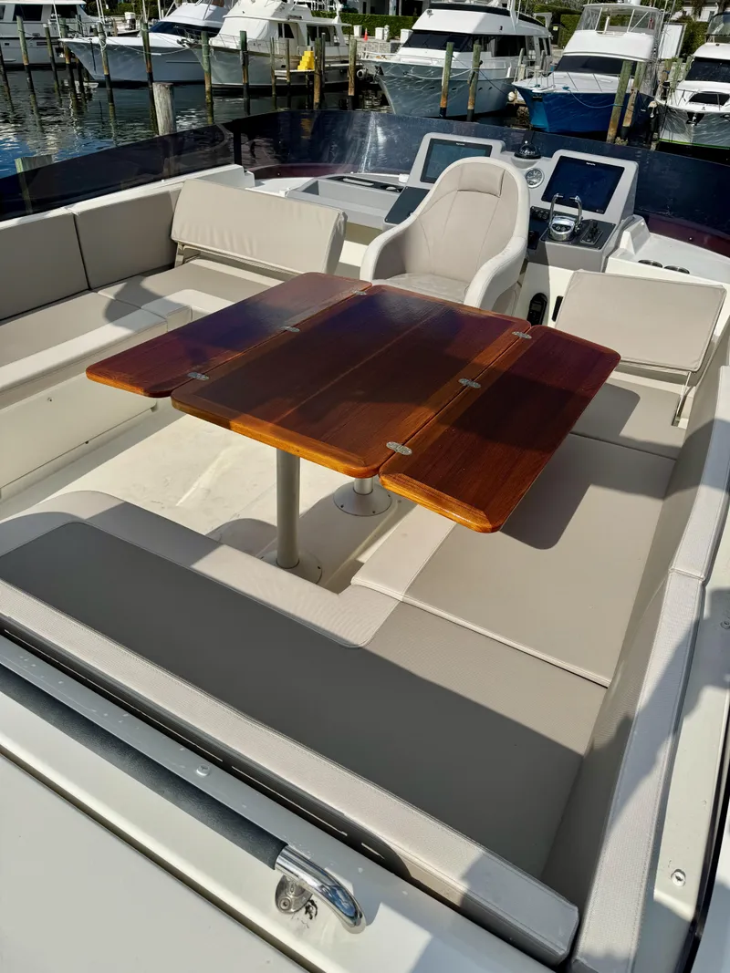 Slide: The Image of 2020 Beneteau Swift Trawler 47 with elegant seating and wooden table on deck. - 26