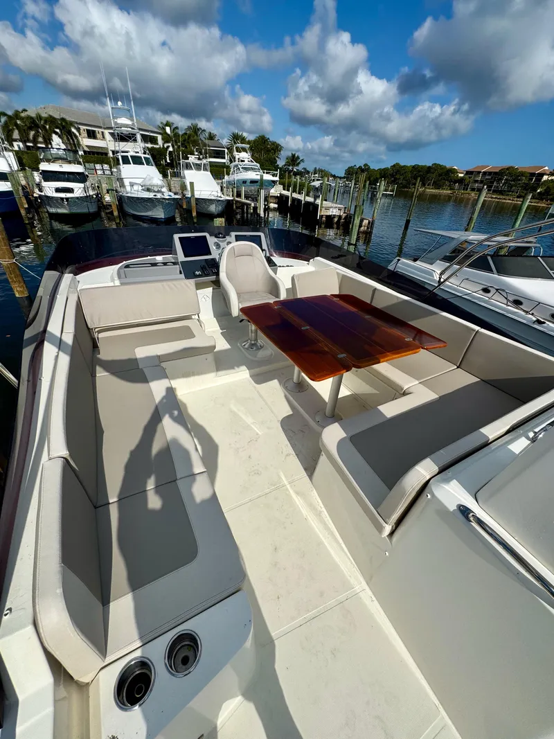 Slide: The Image of 2020 Beneteau Swift Trawler 47, spacious deck with seating and table, docked at marina. - 28