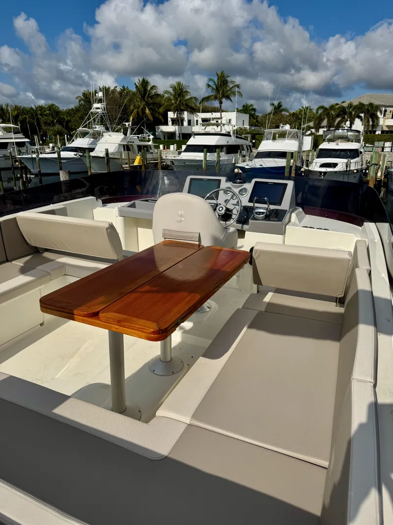 Slide: The Image of 2020 Beneteau Swift Trawler 47 with spacious deck and seating, docked at a marina. - 31