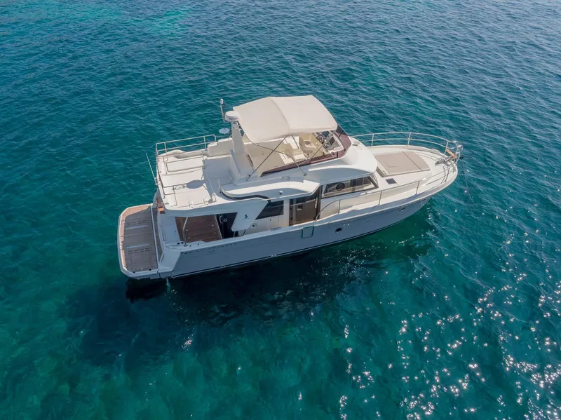 Slide: The Image of 2020 Beneteau Swift Trawler 47 cruising on clear blue water. - 32