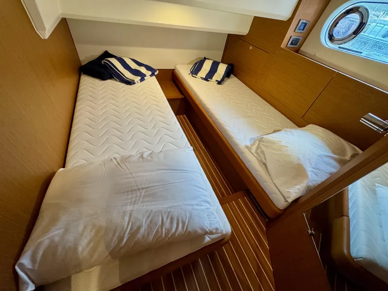 Slide: The Image of 2020 Beneteau Swift Trawler 47 cabin with twin beds and nautical decor. - 7