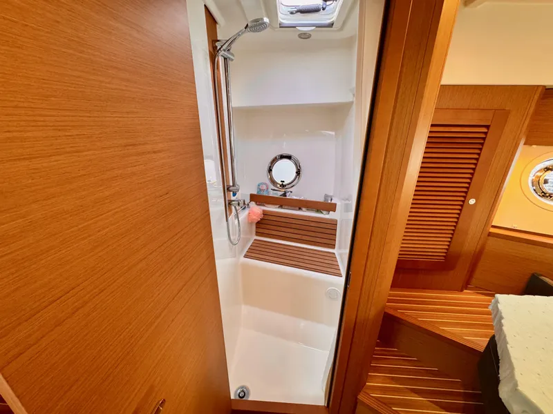 Slide: The Image of 2020 Beneteau Swift Trawler 47 bathroom with wooden accents and shower. - 9