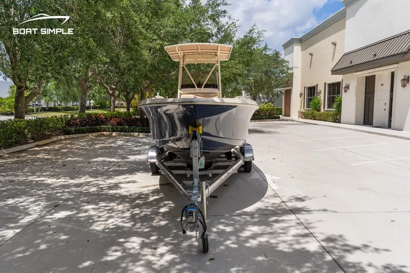 Slide: The Image of 2023 Scout 215 XSF boat on trailer in sunny driveway setting. - 5