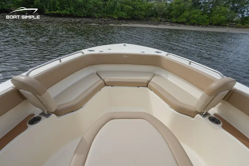 Slide: The Image of 2023 Scout 215 XSF boat interior with cushioned seating, on calm water. - 9
