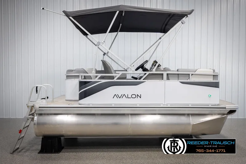 Slide: The Image of 2025 Avalon VEN CR pontoon boat with canopy, side view in showroom setting. - 4