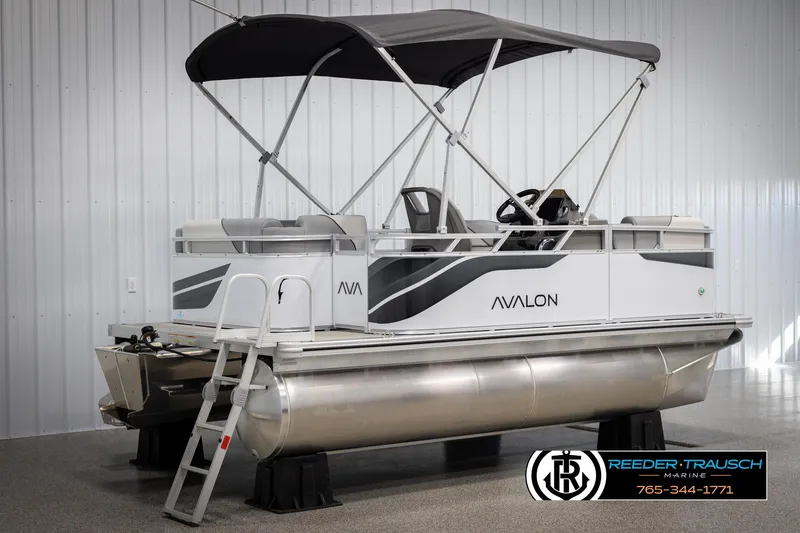 Slide: The Image of 2025 Avalon VEN CR pontoon boat with canopy, displayed indoors at Reeder-Trausch Marine. - 5