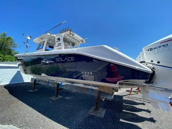 Slide: The Image of 2022 Solace 41 CS boat on stands, blue hull, sunny day. - 2