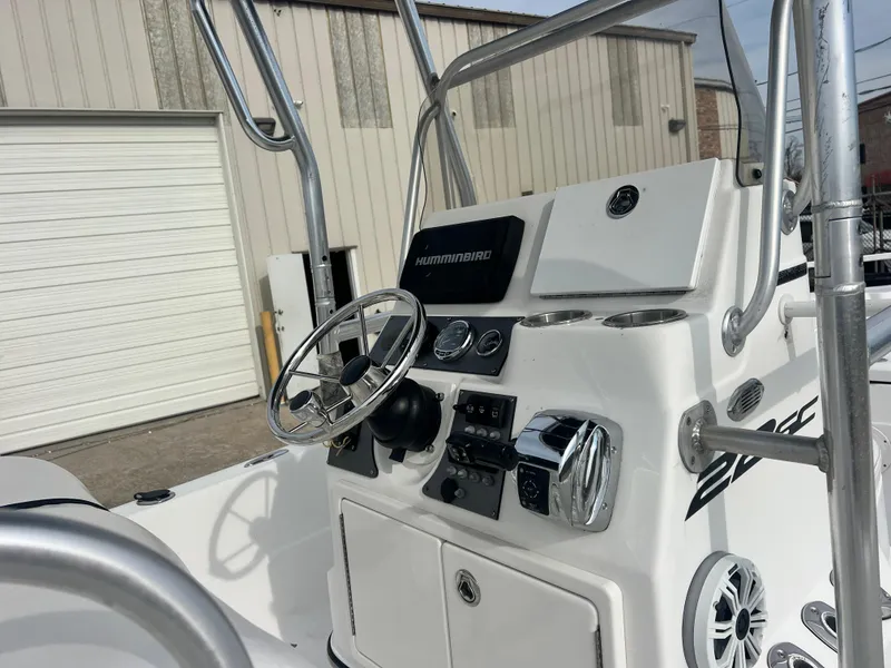 Slide: The Image of 2015 Epic 22 Sport Console boat dashboard with steering wheel and controls, parked near a building. - 3