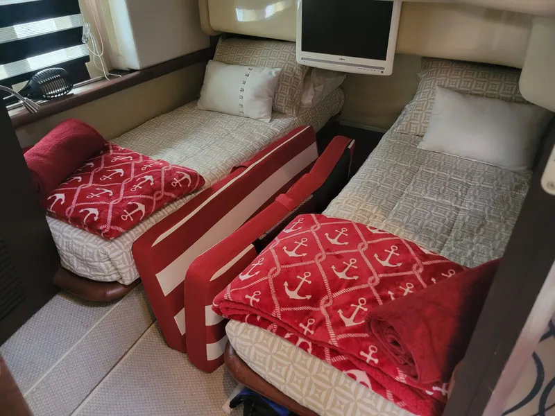Slide: The Image of 2009 Azimut 43S yacht cabin with twin beds, anchor-themed blankets, and a wall-mounted TV. - 36