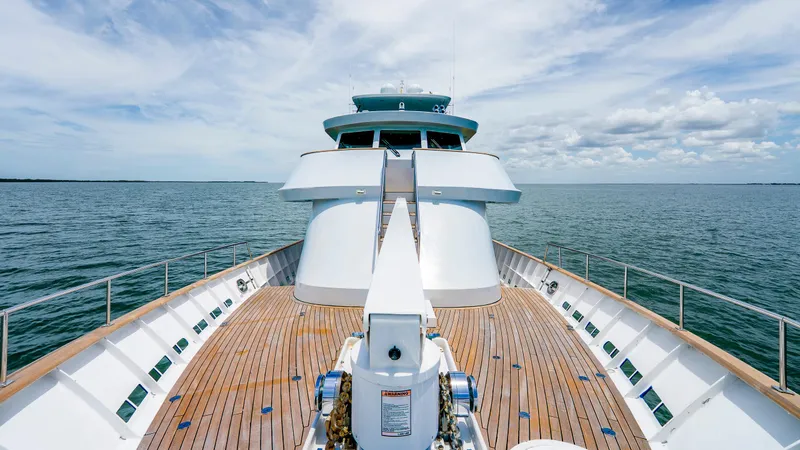 Slide: The Image of 1975 Stephens Brothers Expedition yacht on open sea, featuring wooden deck and clear skies. - 26