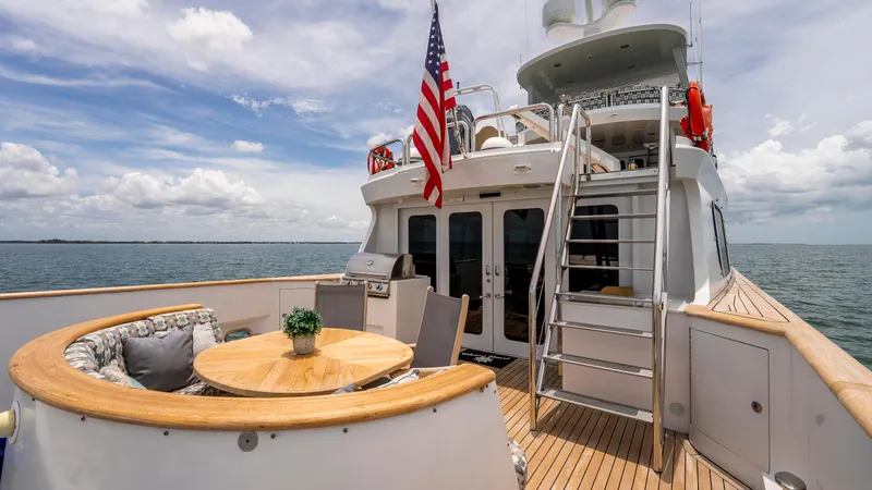 Slide: The Image of 1975 Stephens Brothers Expedition yacht deck with seating, table, and American flag. - 45