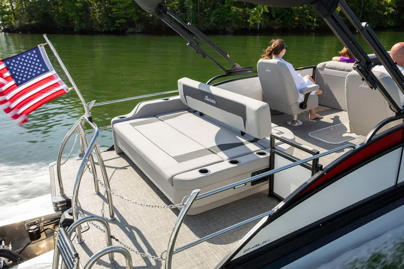 Slide: The Image of 2025 Barletta Aria 24UC pontoon boat cruising on a lake with passengers. - 6