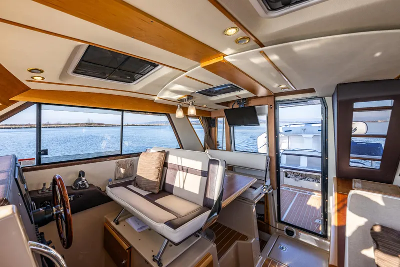 Slide: The Image of Interior of 2016 Cutwater 30 Command Bridge boat with seating and helm, overlooking water. - 17