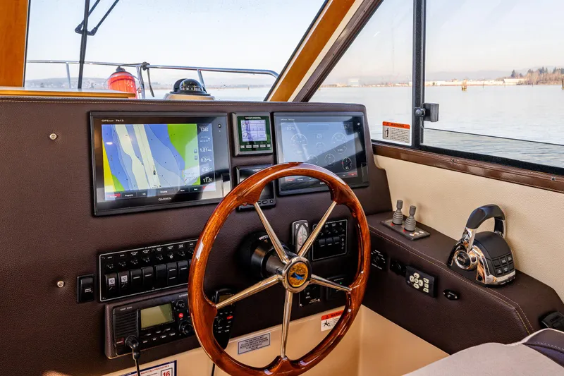 Slide: The Image of Helm of 2016 Cutwater 30 Command Bridge with navigation screens and steering wheel. - 19