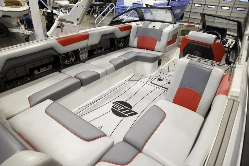 Slide: The Image of 2021 Malibu 25 LSV boat interior with red and gray seating, modern design. - 16