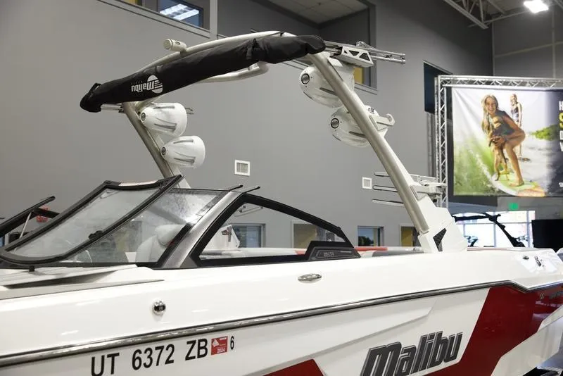 Slide: The Image of 2021 Malibu 25 LSV boat with wakeboard tower, displayed indoors. - 7