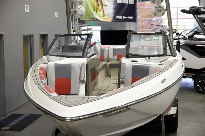 Slide: The Image of 2021 Malibu 25 LSV boat with red and gray interior on display indoors. - 8