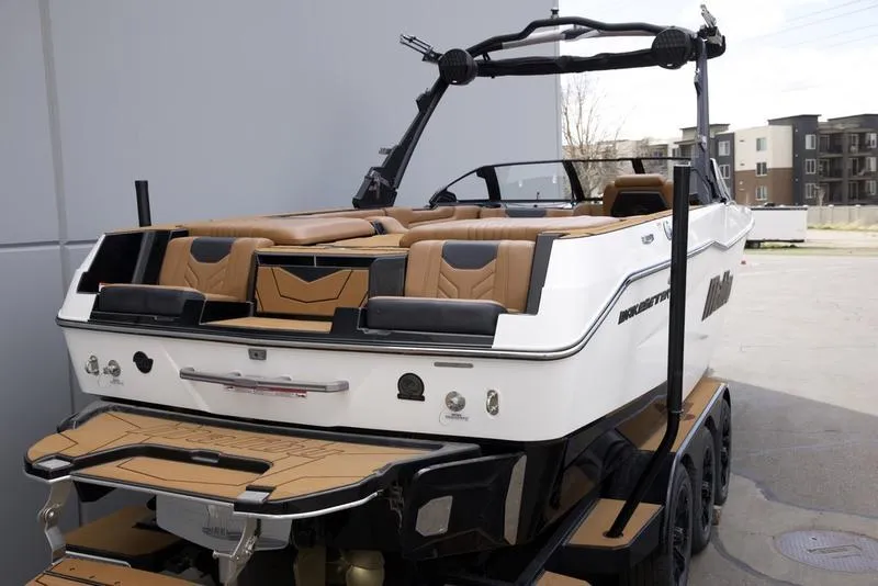 Slide: The Image of 2025 Malibu 25 LSV boat with tan seating and sleek design on a trailer. - 11