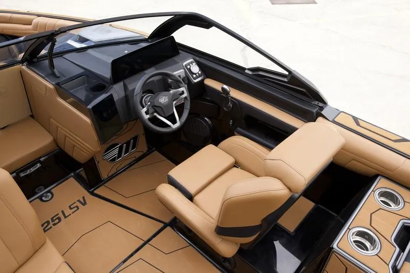 Slide: The Image of Interior of 2025 Malibu 25 LSV boat with tan seating and modern dashboard. - 13