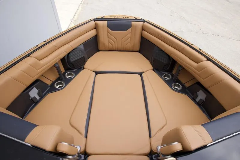 Slide: The Image of 2025 Malibu 25 LSV boat interior with tan leather seating and cup holders. - 16