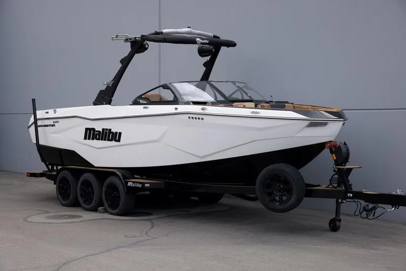 Slide: The Image of 2025 Malibu 25 LSV boat on trailer, sleek design, white and black color scheme. - 2