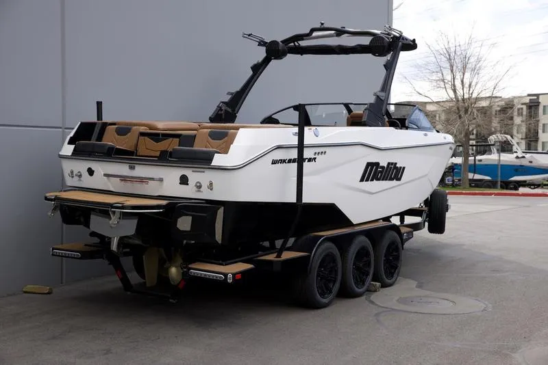 Slide: The Image of 2025 Malibu 25 LSV boat on trailer, parked outdoors. - 4
