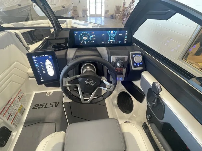 Slide: The Image of 2025 Malibu 25 LSV boat cockpit with modern steering and digital displays. - 15
