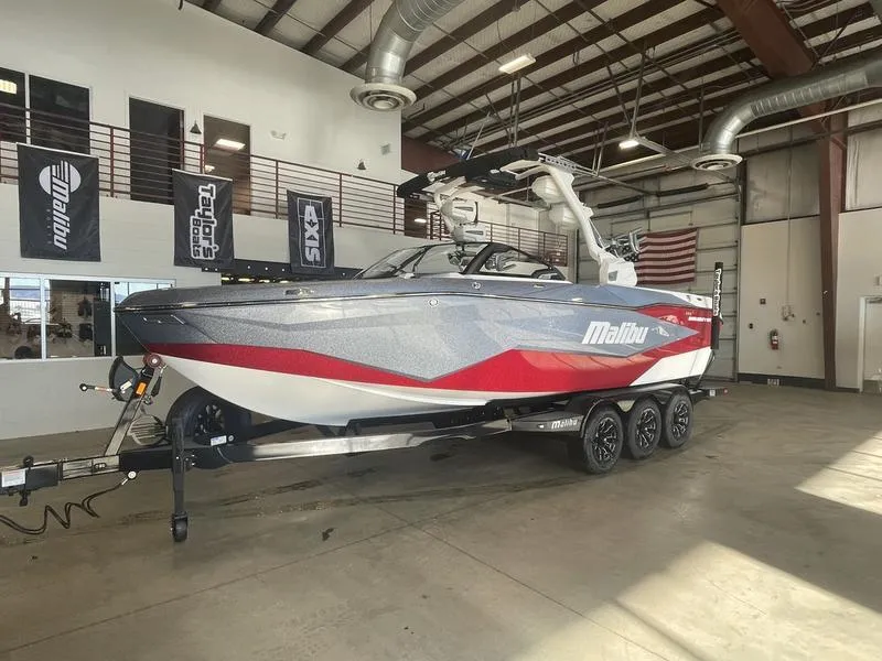 Slide: The Image of 2025 Malibu 25 LSV boat in showroom, featuring sleek design and vibrant red accents. - 3