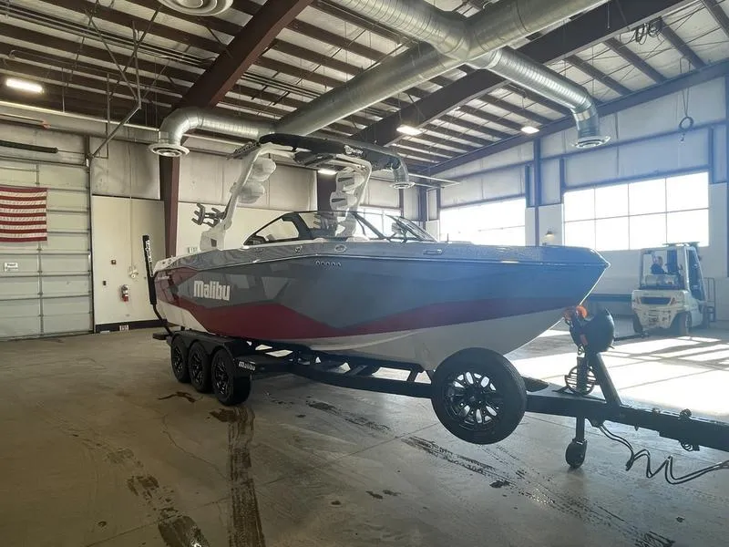 Slide: The Image of 2025 Malibu 25 LSV boat on trailer in warehouse setting. - 5