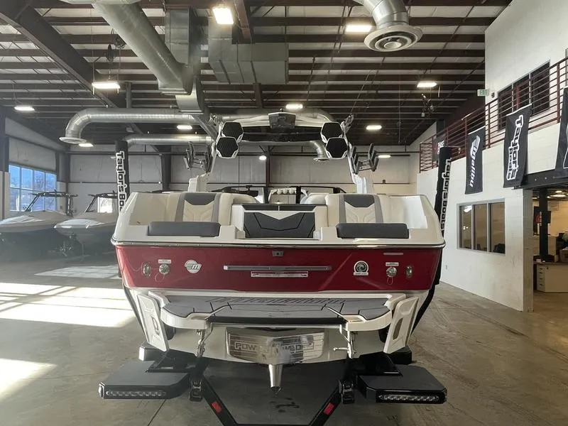 Slide: The Image of 2025 Malibu 25 LSV boat in showroom, rear view, red and white design. - 8