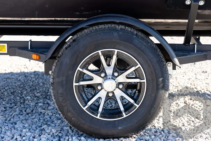 Slide: The Image of 2025 G3 Sportsman 1610 trailer wheel on gravel surface. - 26