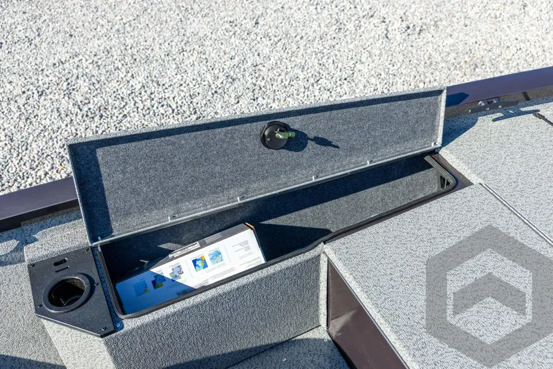 Slide: The Image of Open storage compartment on 2025 G3 Sportsman 1610 boat, featuring cup holder and key. - 34