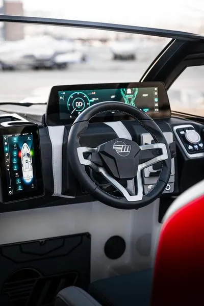 Slide: The Image of 2025 Malibu 25 LSV boat dashboard with modern digital displays and steering wheel. - 4