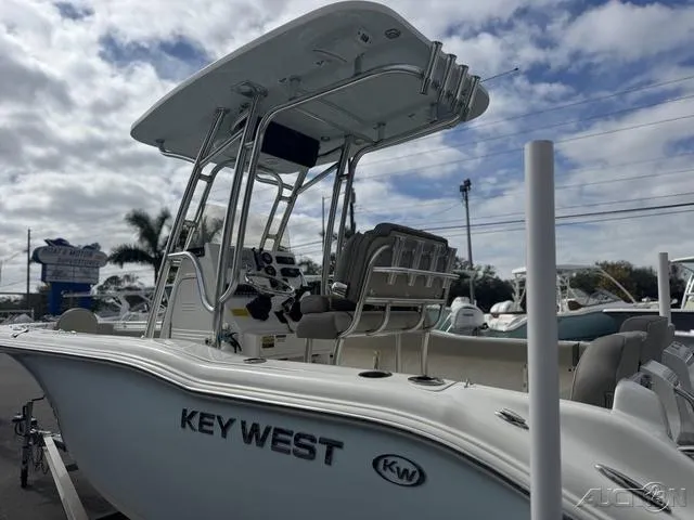 Slide: The Image of 2021 Key West 219fs boat with T-top and seating, displayed outdoors under cloudy sky. - 6