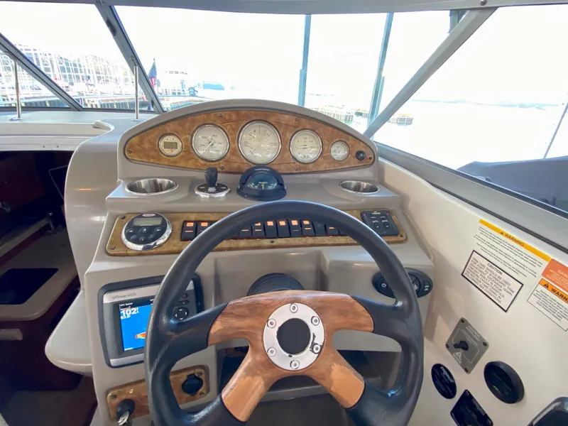 Slide: The Image of 2008 Rinker 280 Express Cruiser helm with wood accents and modern controls. - 10