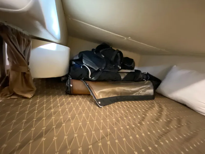 Slide: The Image of 2008 Rinker 280 Express Cruiser cabin interior with storage bags on bed. - 15