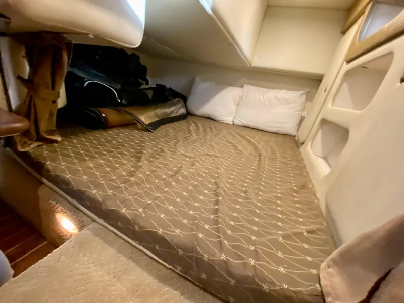 Slide: The Image of 2008 Rinker 280 Express Cruiser cabin with cozy bed and storage space. - 16