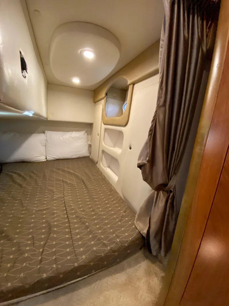 Slide: The Image of 2008 Rinker 280 Express Cruiser cabin with bed, pillows, and curtain. - 17