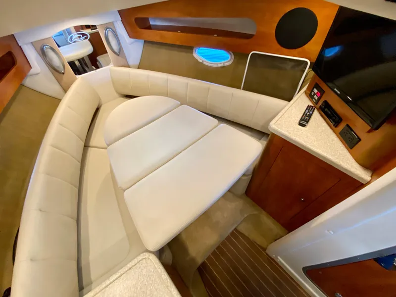 Slide: The Image of 2008 Rinker 280 Express Cruiser interior with beige seating and modern amenities. - 18